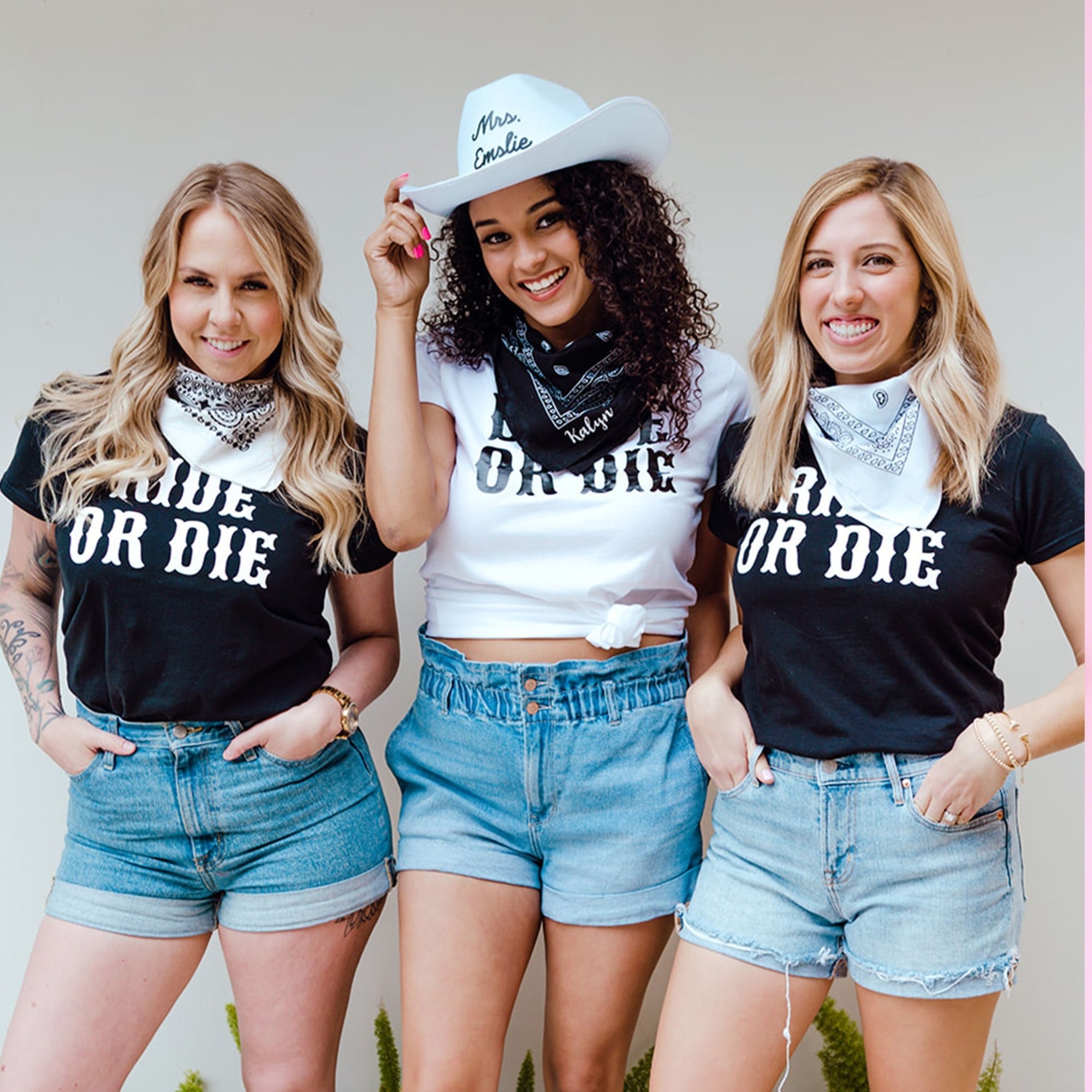 A bride and her friends wear matching bachelorette shirts which say "Bride or Die" and bandanas.
