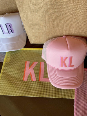 Shadow monogram trucker hat with embroidered initials on front panel, structured cap with mesh back