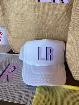 Shadow monogram trucker hat with embroidered initials on front panel, structured crown with mesh back