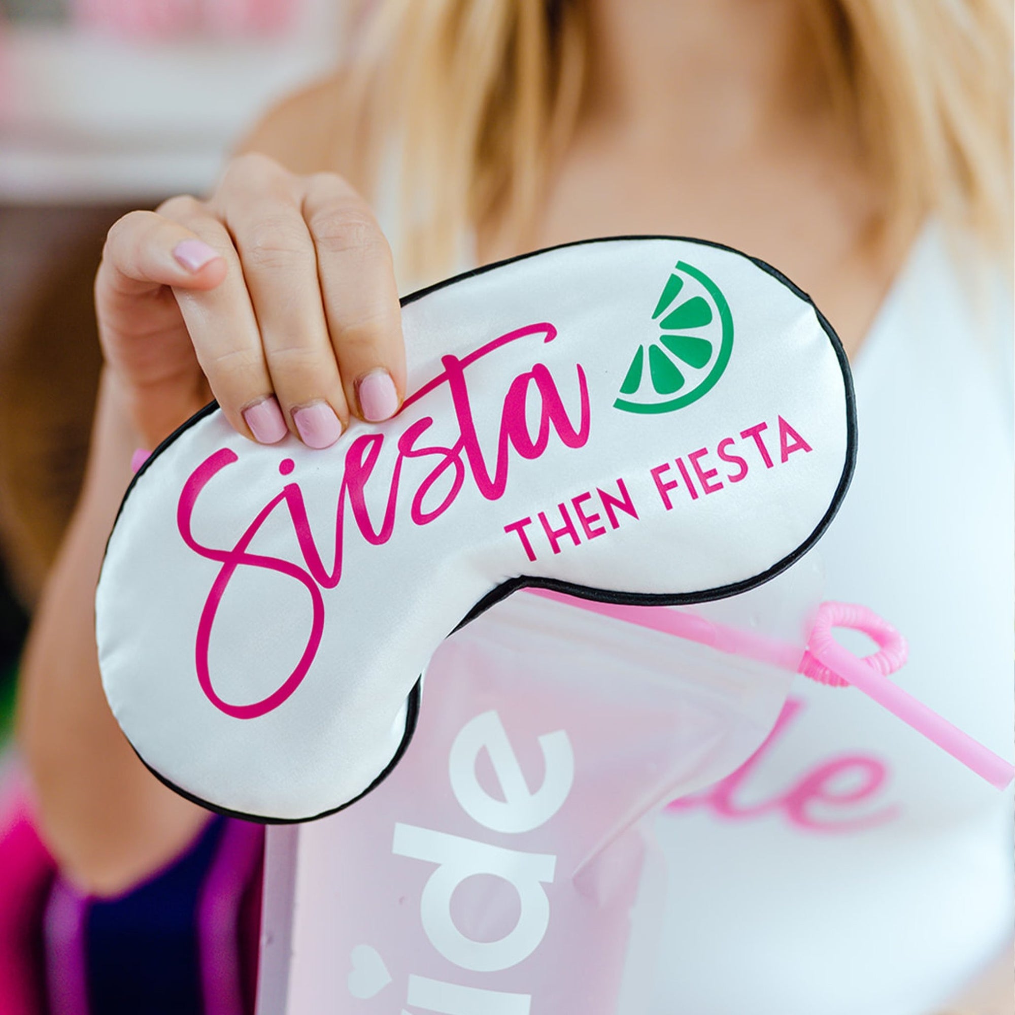 Pink and white sleep masks are customized with a pink design that says "Siesta then Fiesta".