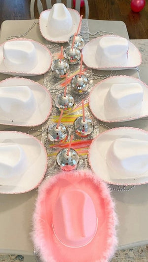 Disco ball tumblers sit on a table with cowboy hats
