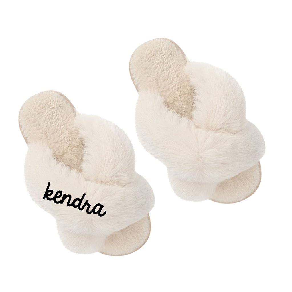Pair of customizable bridal plush slippers with 'kendra' on the strap.