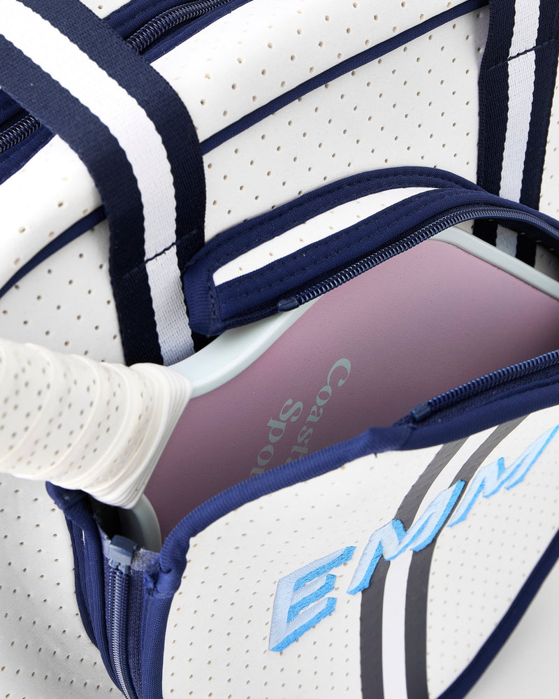 A monogrammed pickleball bag with blue lettering