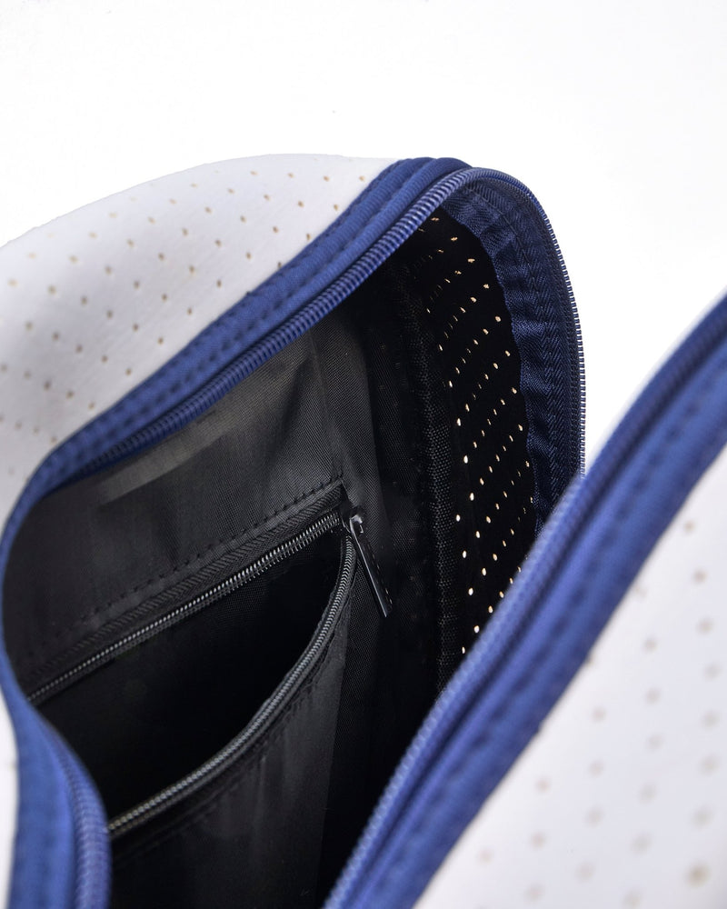 A navy and white pickleball bag is opened to show the interior zipper pocket.