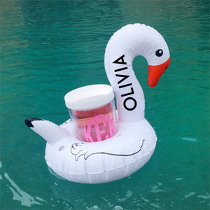 A swan pool drink float is customized with the name "Olivia"
