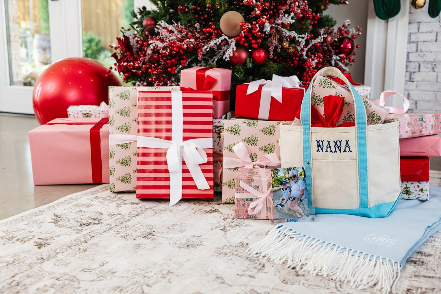 A Pile Of Christmas Presents Under A Christmas Tree, Including A Personalized Gift For Grandmas