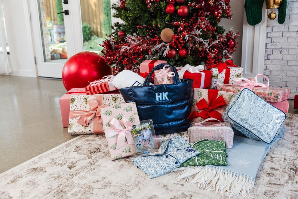 A pile of Christmas presents under a Christmas tree, featuring personalized gifts for moms and mother in laws from Sprinkled With Pink.