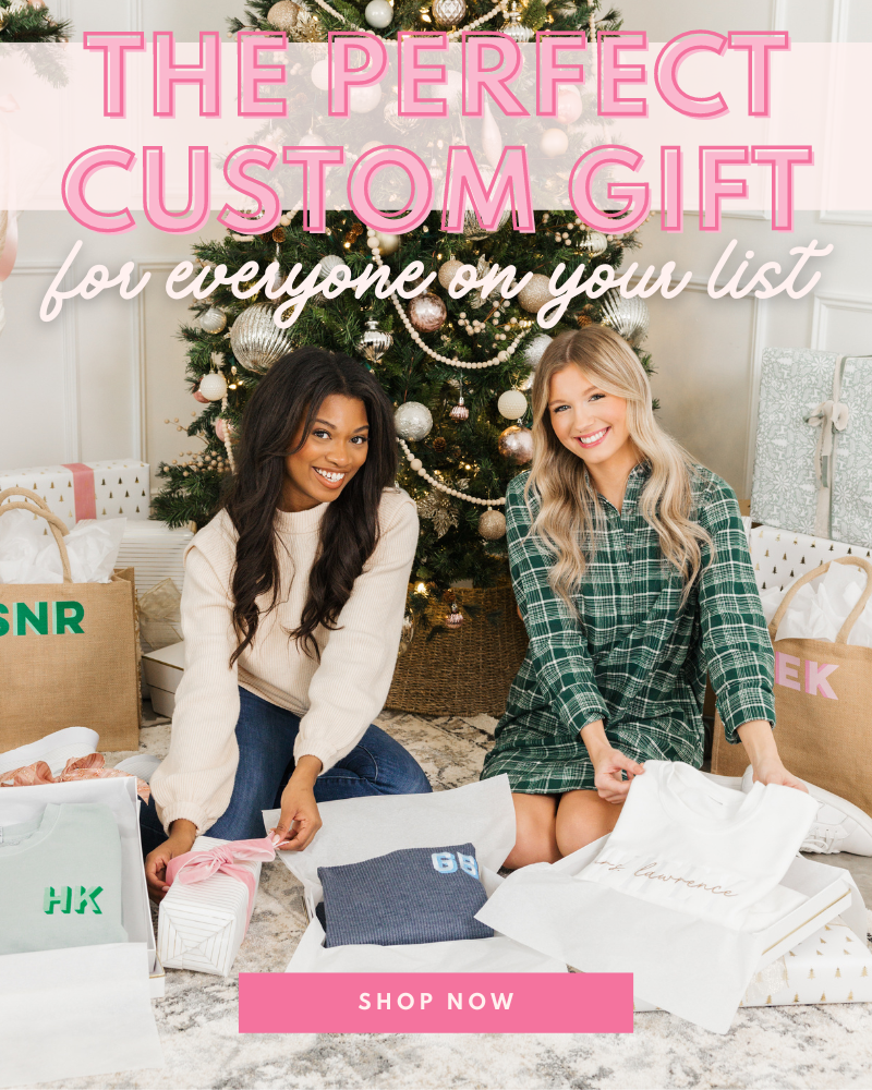 Two girls in front of a Christmas tree, smiling while opening personalized, custom gifts 