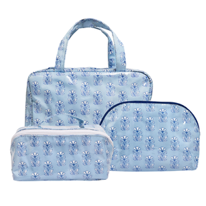Three-piece light blue travel set featuring a tote bag, a zippered pouch, and a zippered case, all decorated with a matching blue floral block print pattern.