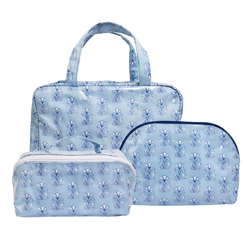 Three-piece light blue travel set featuring a tote bag, a zippered pouch, and a zippered case, all decorated with a matching blue floral block print pattern.