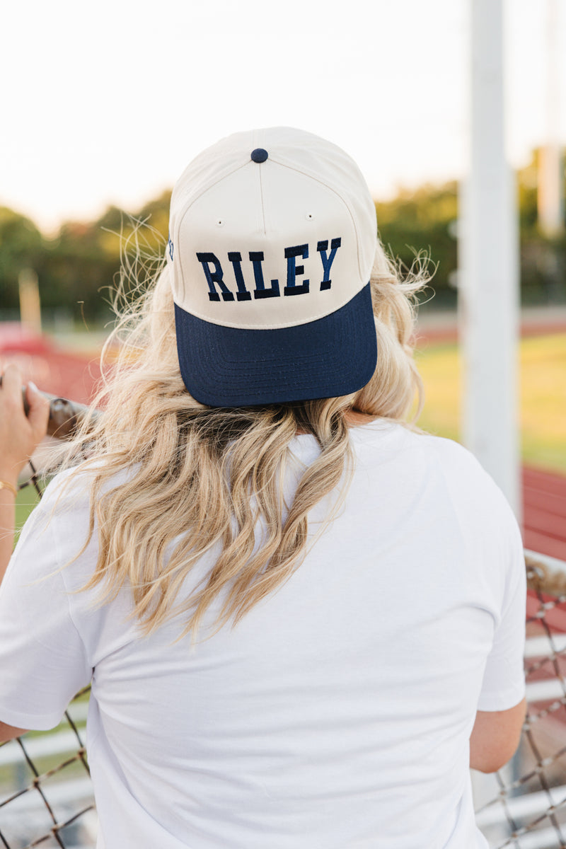 Woman wearing personalized vintage trucker hat with embroidered text.