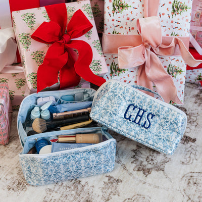 Personalized gift sets with flat lay pouches under the Christmas tree.