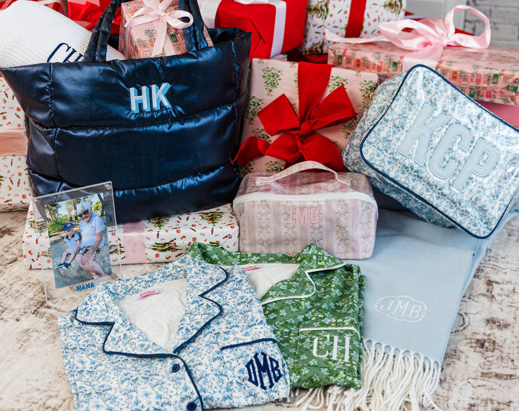 Festive gift scene with personalized travel pouches, totes, PJ's and blankets under the tree.