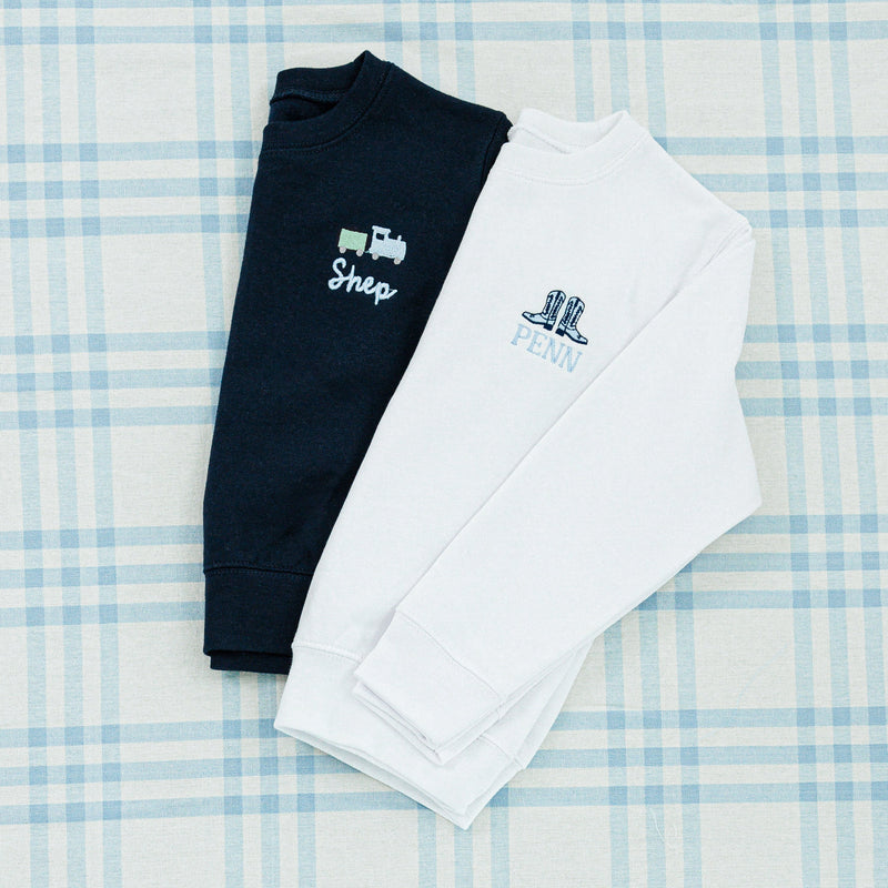 Two personalized sweaters, one in navy and the other in light gray.
