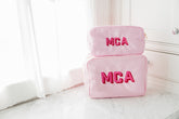 Pink pouches personalized, sitting on a bathroom counter