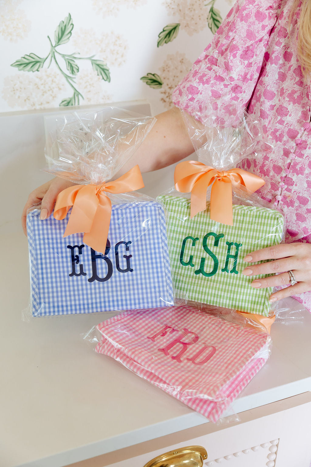 Personalized gingham TRVL Roadie bags in blue, pink, and green with monogram and name embroidery
