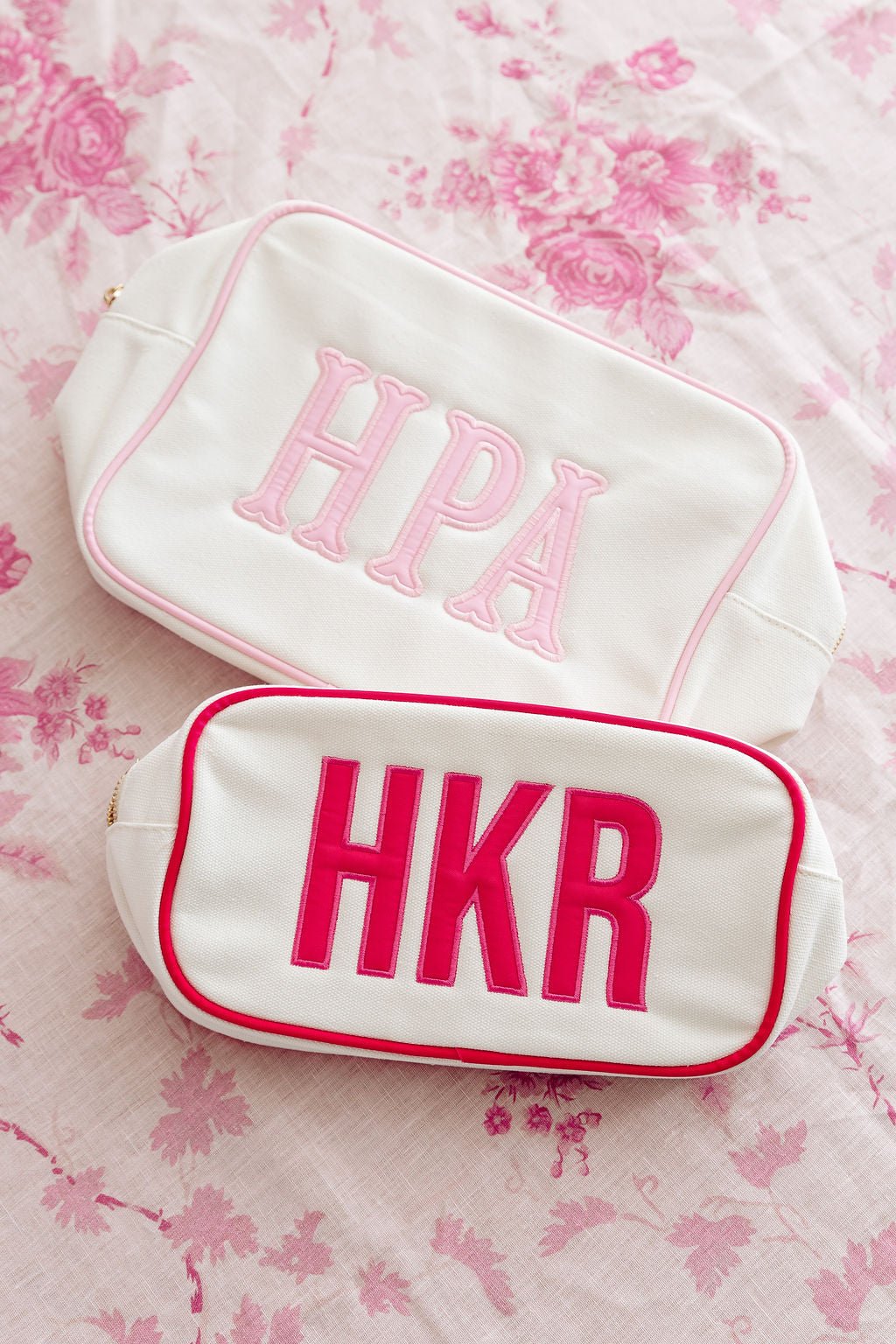 Pink embroidered canvas pouch set in two sizes, ideal for travel or gifts.