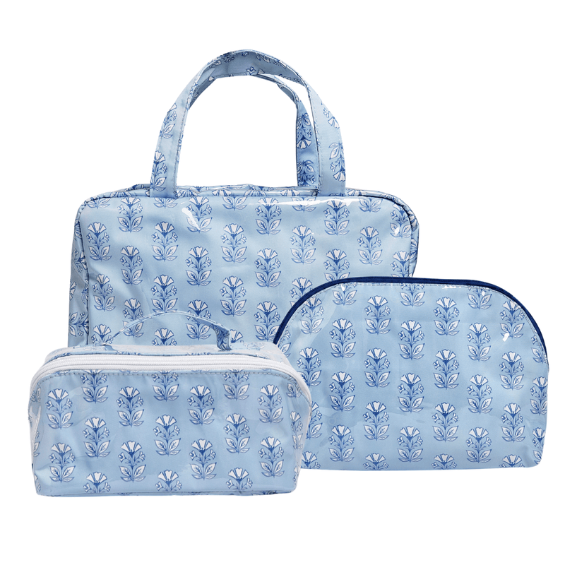 Three-piece light blue travel set featuring a tote bag, a zippered pouch, and a zippered case, all decorated with a matching blue floral block print pattern.