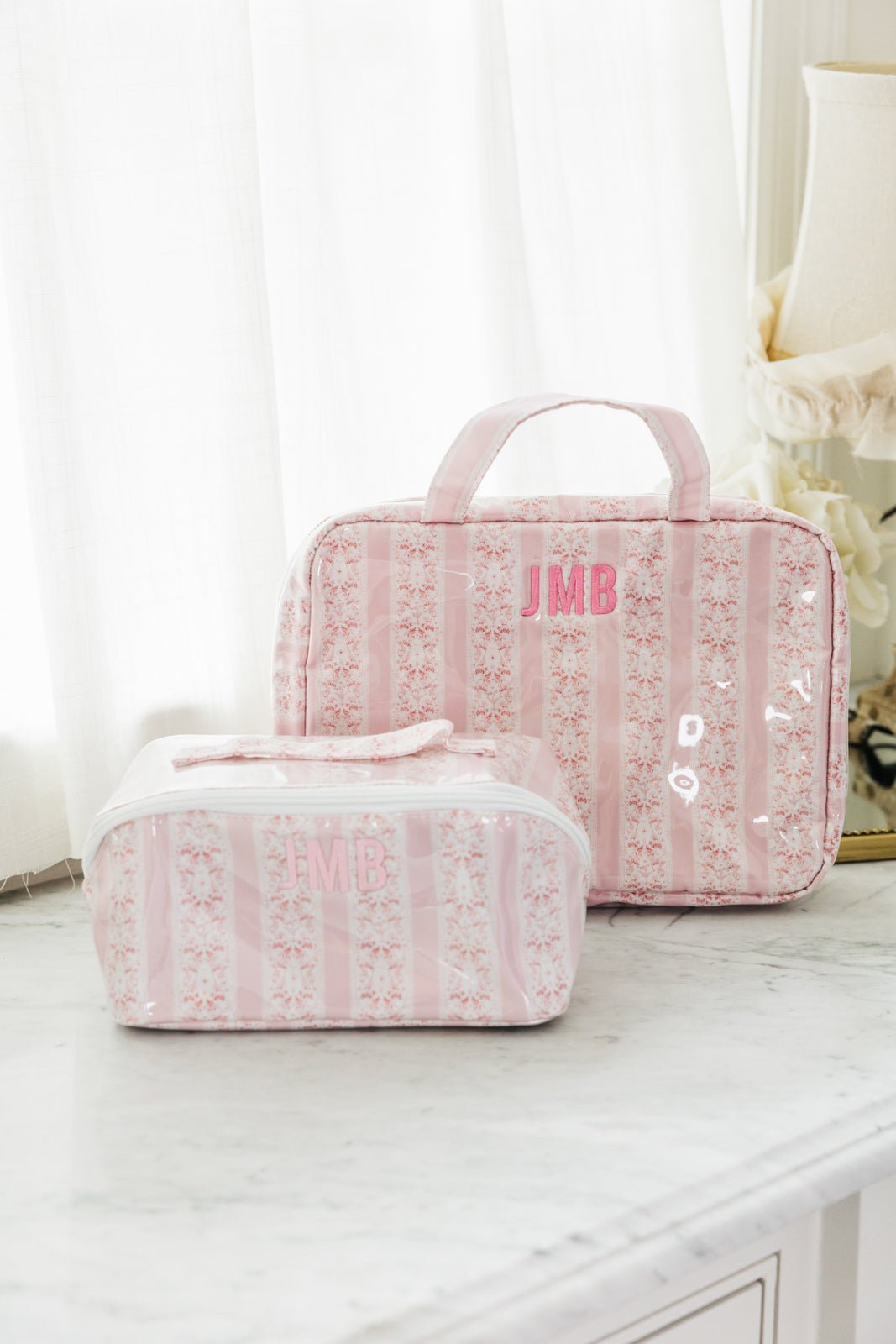 Blue floral Clear Coated Travel Set with monogram "KND," includes two matching cosmetic and travel bags.