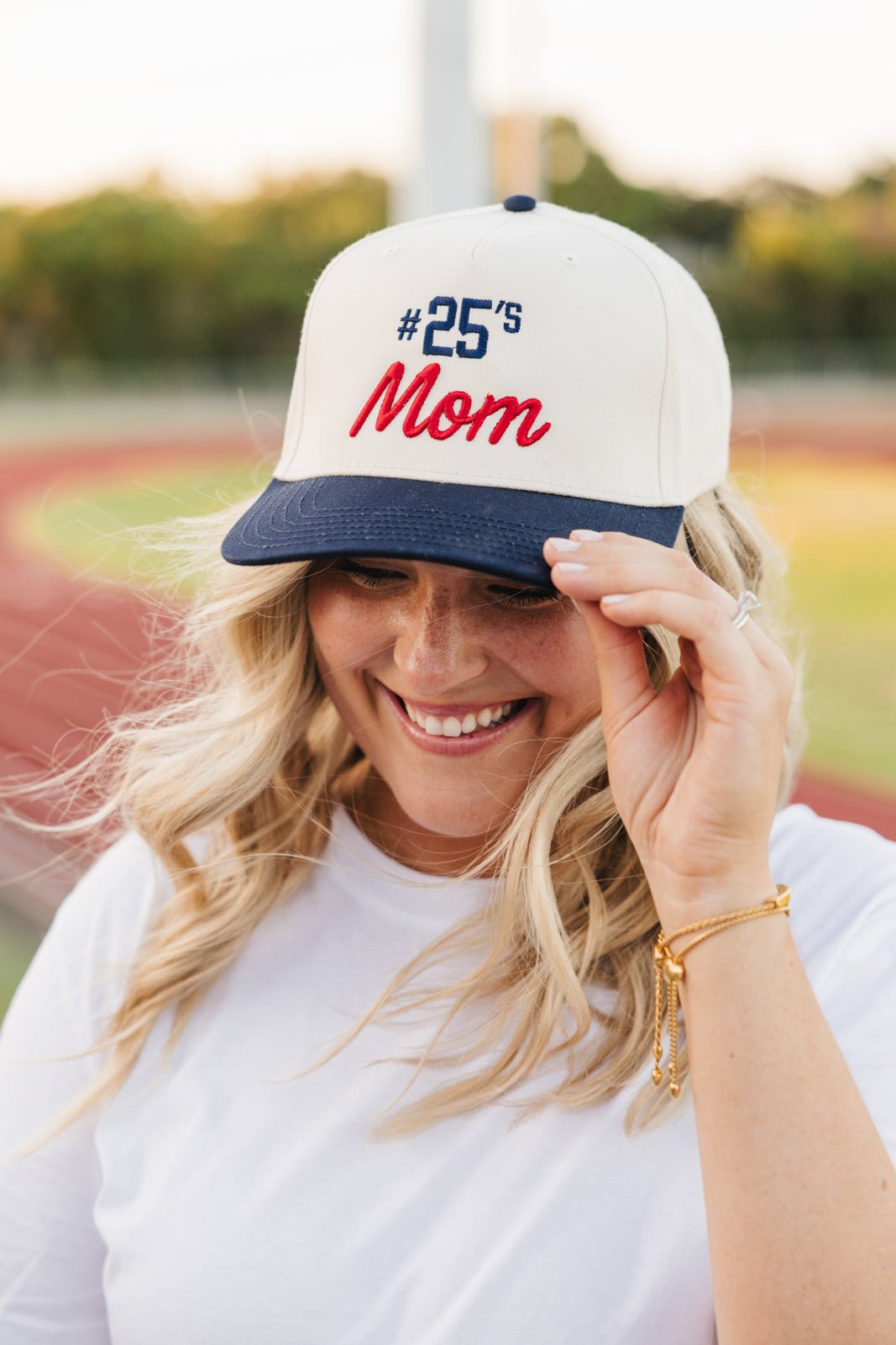 Cream vintage trucker hat with black brim, embroidered “#12’s Mom” in black and green 3D puff.