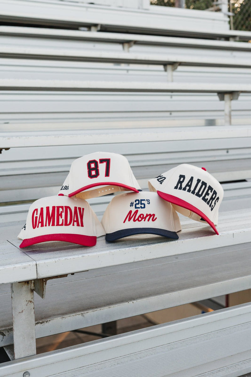 Bleachers lineup of vintage trucker hats, featuring an Embroidered Jersey Number Vintage Trucker Hat with bold red “87”.