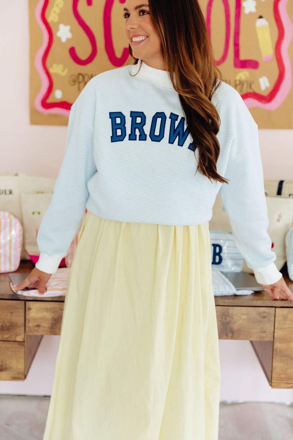 Light pink mockneck sweatshirt embroidered with 'CONDER' in pink collegiate block letters