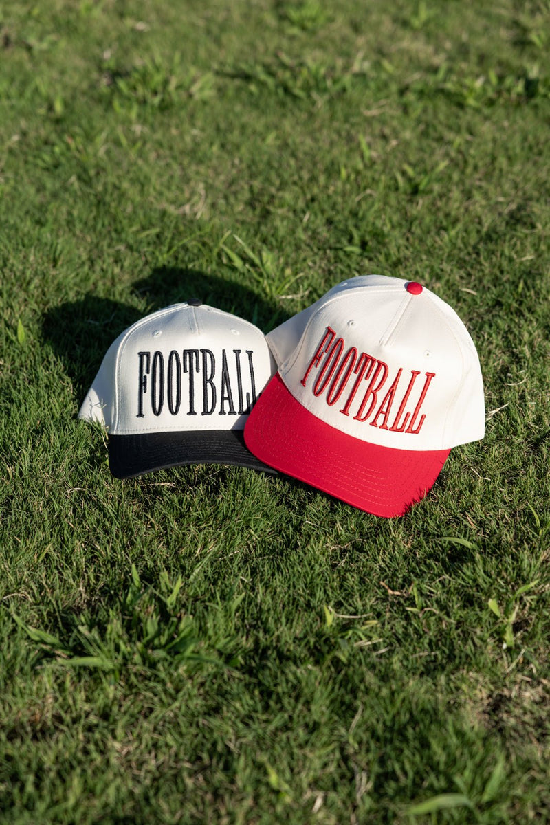 Black-brim and red-brim “FOOTBALL” caps displayed on field—Custom Sport 3D Puff Vintage Trucker Hat.