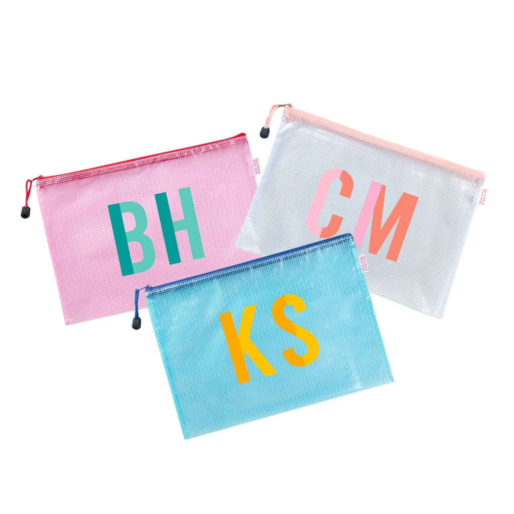 A pink, white, and blue pool bag are monogrammed with duo colored monograms.