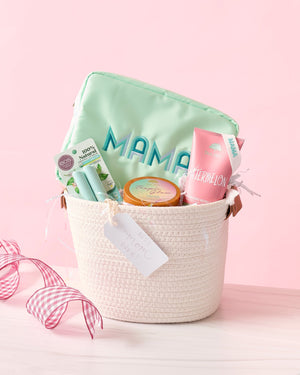 A mint nylon pouch is customized with "Mama" and placed in a basket with self care items.