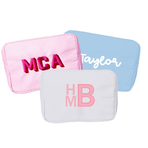 A group of a extra large nylon pouches are customized with embroidered monograms and names