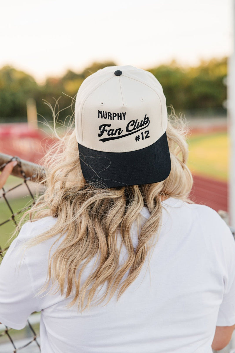 Back view at the track, model wears Embroidered Fan Club Vintage Trucker Hat, “Murphy Fan Club #12.”