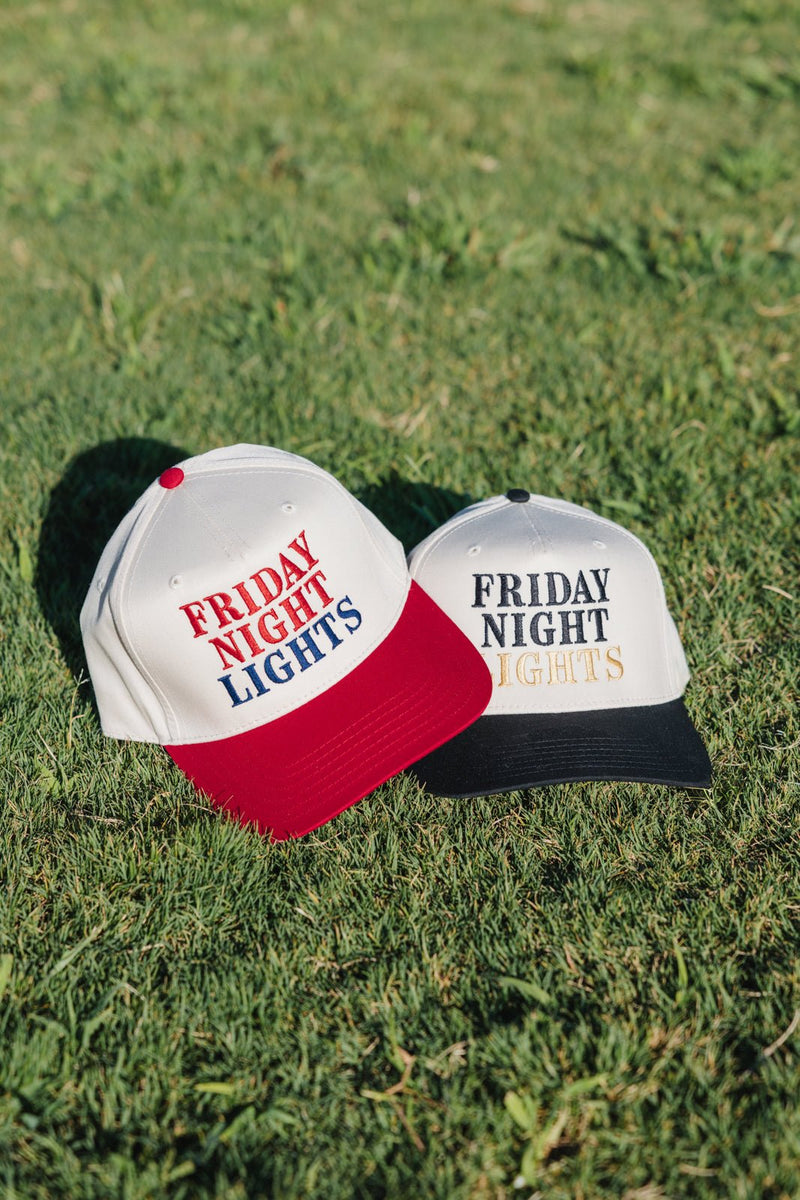 Red and black brims stacked on grass, Friday Night Lights logo.