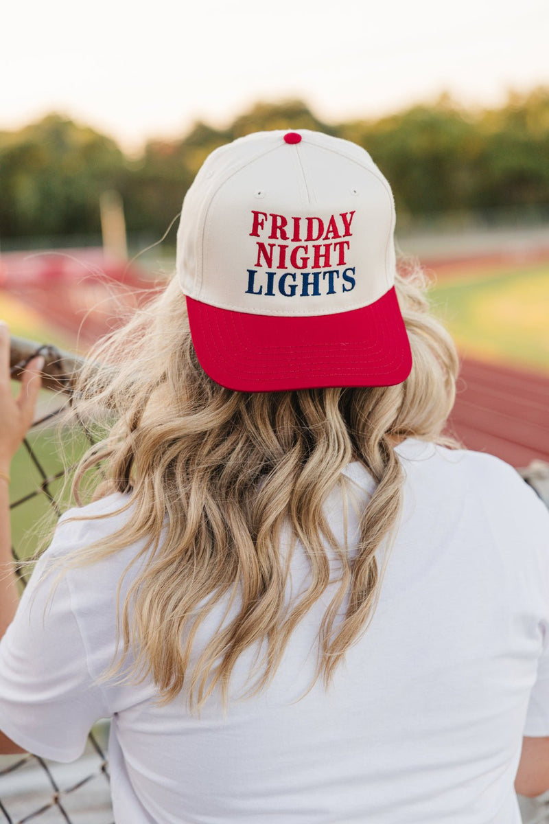 Back view at field: red-brim cap worn backward; embroidered Friday Night Lights.