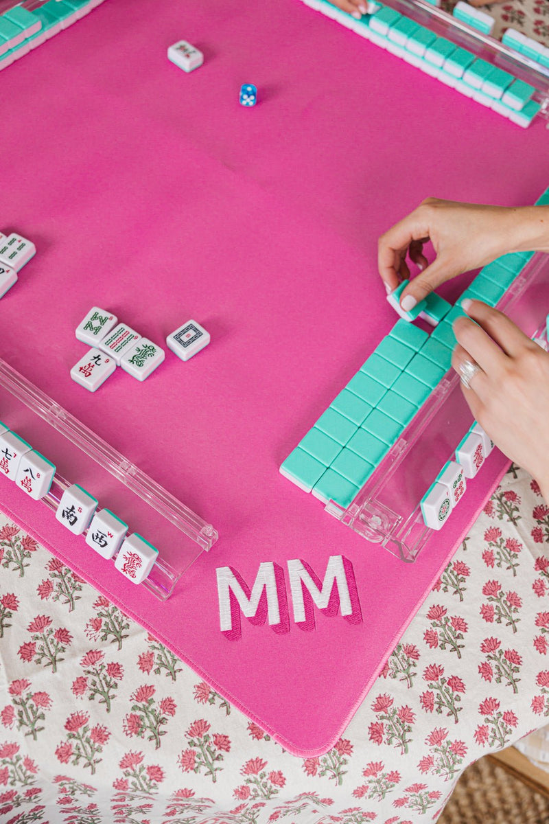 Pink Embroidered Monogram Mahjong Tile Mat with tiles and racks laid out for a fun match.
