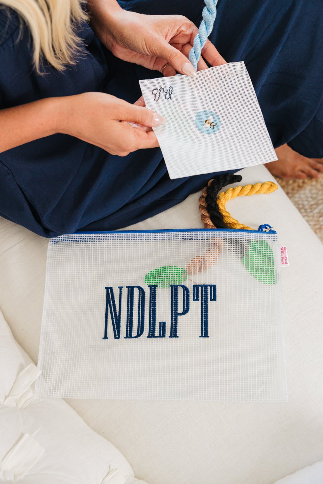 Three custom embroidered mesh pouches displayed against a white background. The first pouch is pink with the name 'Harper' in script embroidery, the second pouch is white with the monogram 'EMG' in pink embroidery, and the third pouch is blue with the name 'Sophia' in block embroidery.