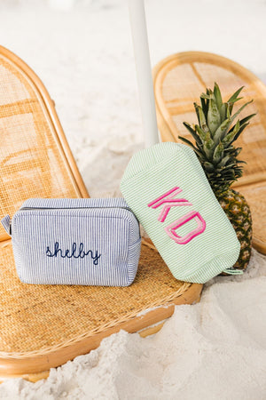 Two seersucker pouches are customized with an embroidered monogram and name