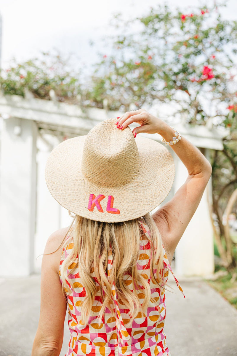 Embroidered straw beach hat with personalized monogram, chic sun protection accessory for poolside or vacation.
