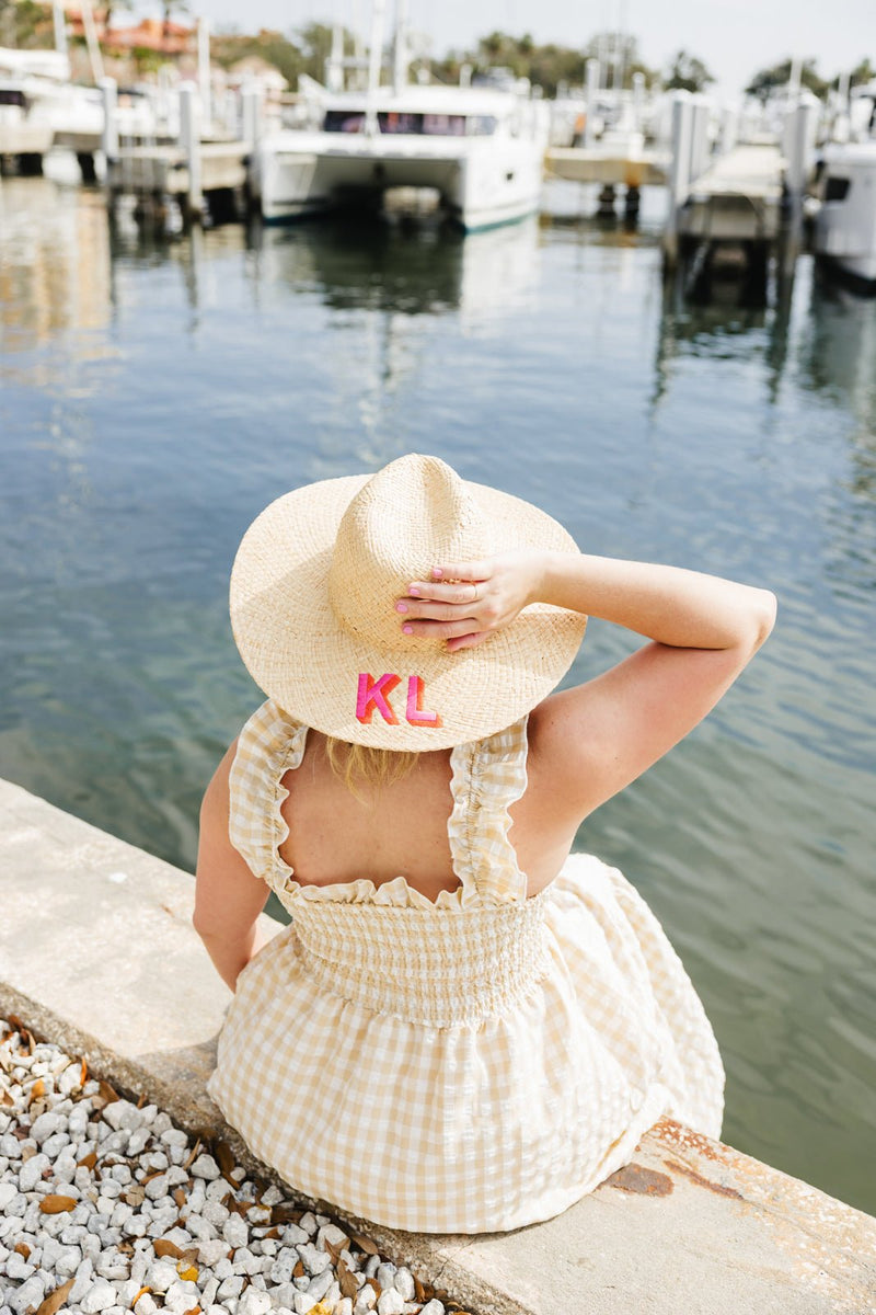 Custom embroidered straw beach hat with wide brim, stylish monogram design for summer beach days.