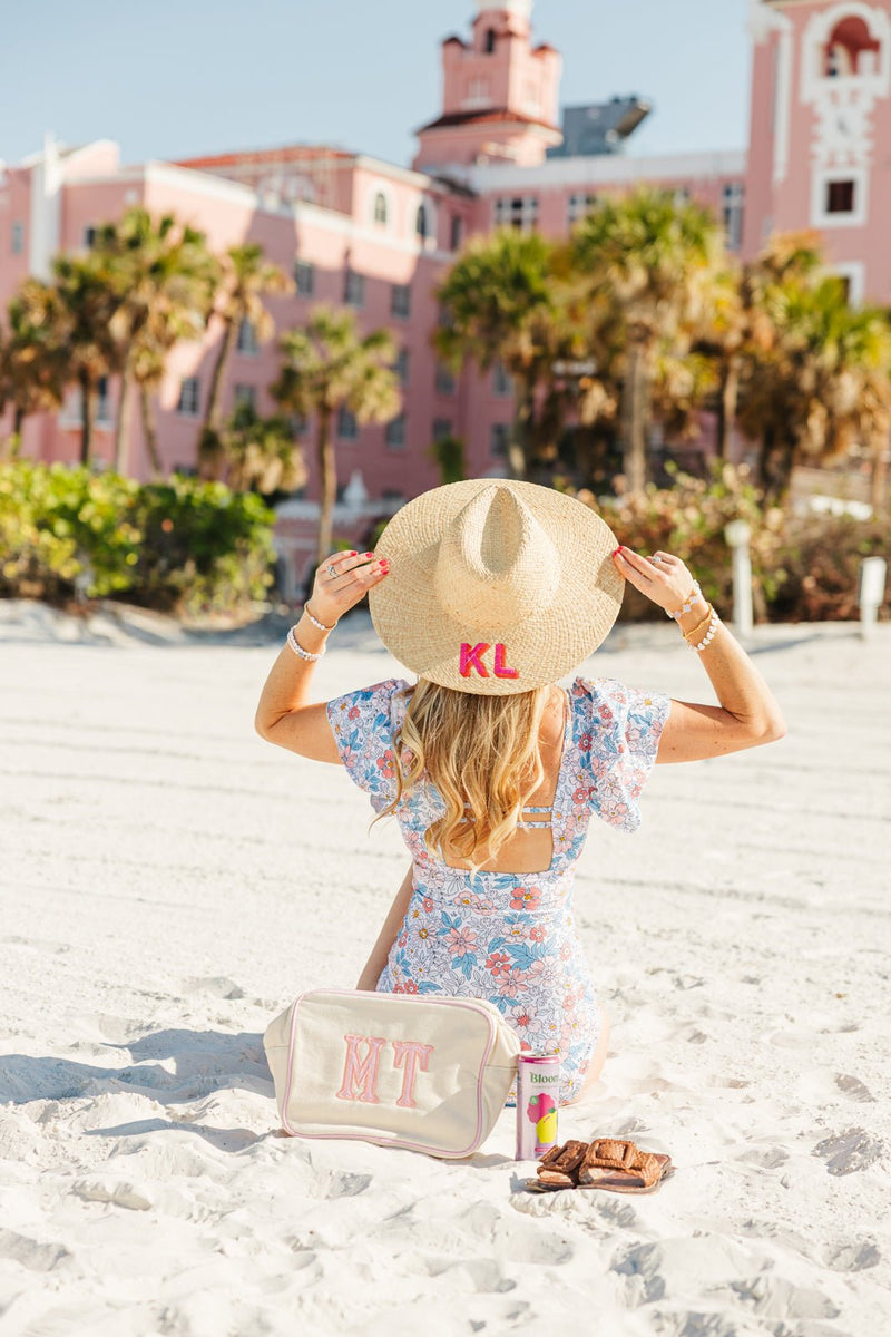Straw beach hat with personalized embroidery, styled for a chic day at the pool or beach.