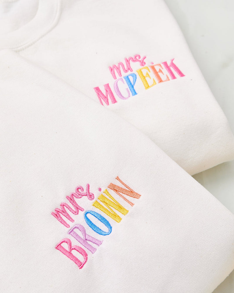Embroidered Teacher Sweatshirts – @PBANDJ4THGRADE x SWP: white cotton crewnecks with pastel rainbow “mrs. McPeek” and “mrs. Brown” embroidery