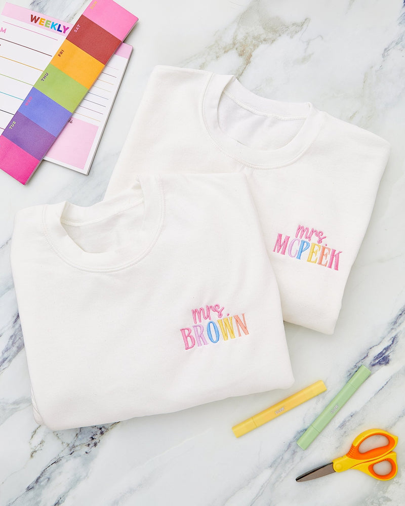 Embroidered Teacher Sweatshirts – @PBANDJ4THGRADE x SWP: white cotton crewnecks with pastel rainbow “mrs. brown” and “mrs. mcpeek” embroidery