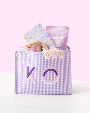 A purple roadie is personalized with a purple and white monogram and filled with goodies.