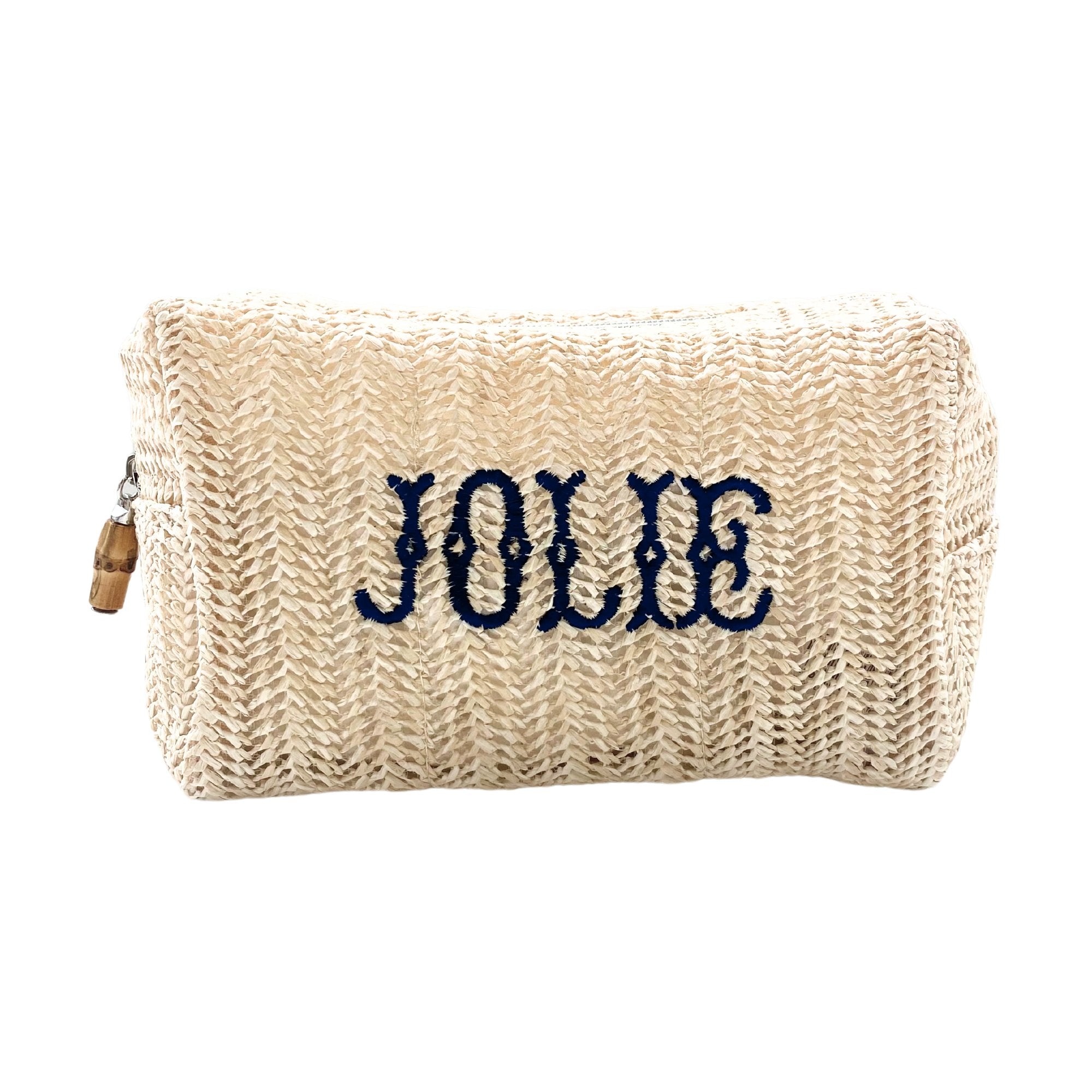 A straw pouch is customized with a name embroidered in navy font