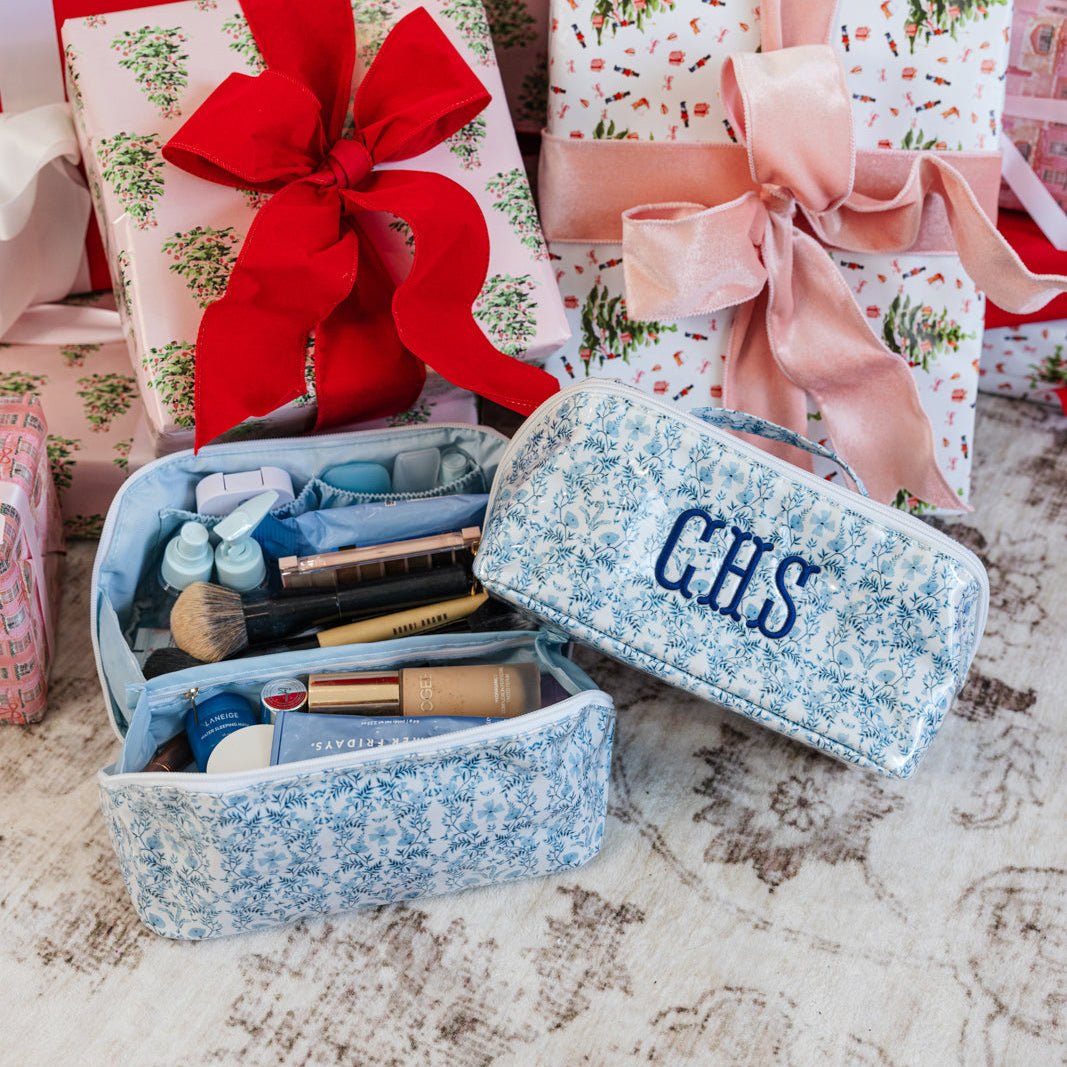 Set of three flat lay pouches in green, pink, and blue floral prints with monogram initials.