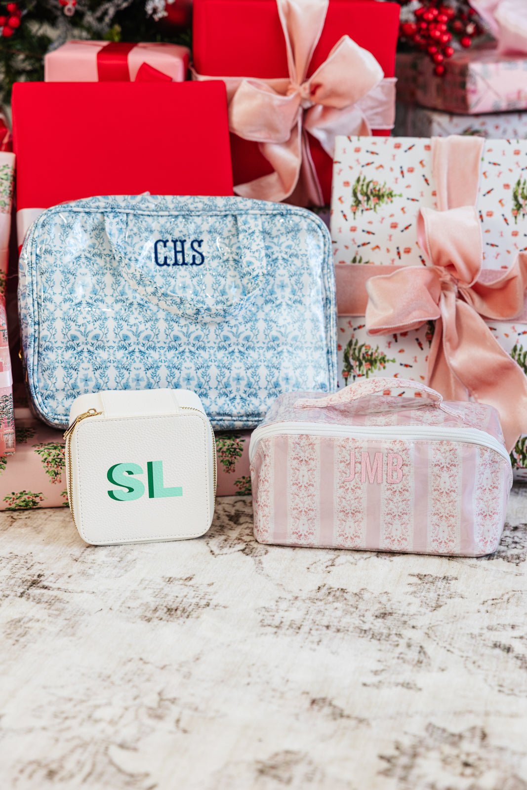 Personalized hanging toiletry bags in pink stripe and blue floral prints with monogram embroidery.