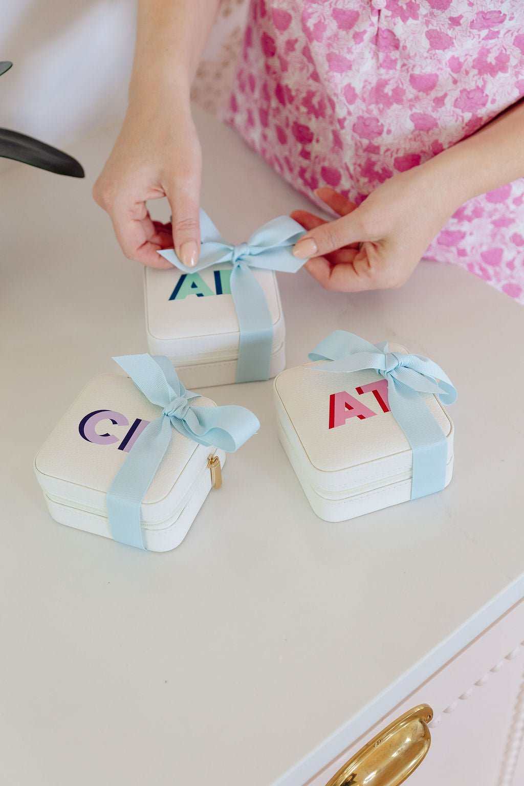 White travel jewelry case with shadow monogram embroidery, shown open with interior compartments