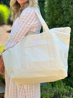 Large cream canvas tote bag with subtle monogram 'ARH' in light pink.