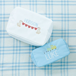 Two personalized pouches. The top pouch is white with 'Hudson' embroidered in blue