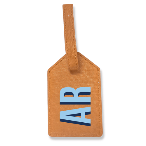 Tan saffiano leather luggage tag with an adjustable strap, monogrammed 'AR' in light blue and navy.