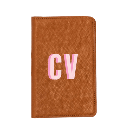 Brown saffiano leather passport holder monogrammed 'CV' in pink.